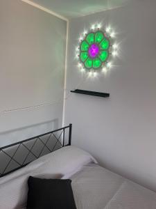 a bedroom with a bed with a green flower on the wall at Illumina House 3 in Giurdignano