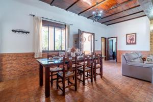 a dining room with a table and chairs and a couch at Casa Rural Villa Lucrecia in La Lantejuela