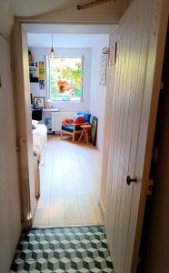 a hallway with a room with a bed and a window at Chambre et Salle de bain privées avec vue sur jardin dans maison familiale in Montreuil