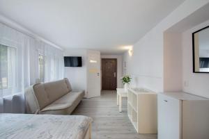 a room with a bed and a couch and a table at Leokadia przy plaży kwatery prywatne in Mielno