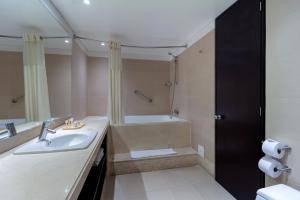 a bathroom with a sink and a bath tub at Hotel Madisson Inn Luxury By GEH Suites in Bogotá