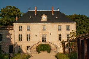 a large building with a black roof and stairs at Coureilles Appartements et Suites in La Rochelle