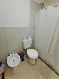 a bathroom with a white toilet and a sink at SAN jose in Federación +6 photos