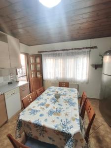 a kitchen with a table and chairs and a kitchen with a table and a table at Amelie's Stone House in Vathý