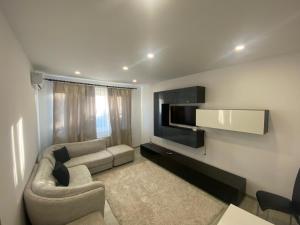 a living room with a couch and a flat screen tv at Apartament Kiri in Mangalia