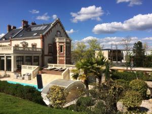 a large house with a swimming pool in front of it at Hôtel La Villa Eugene in Épernay