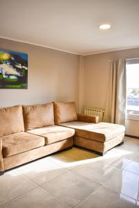 a living room with a couch and a window at Demetrio Hotel Apart in Olavarría