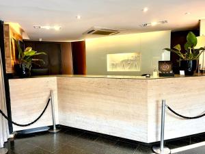 a reception desk in a lobby with plants at Oasis Plaza Hotel in Ribeirão Preto