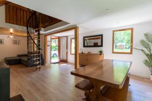 a living room with a wooden table and a staircase at Chalet du Lacus in Boutx