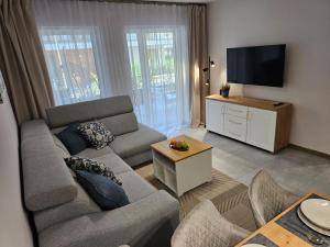 a living room with a couch and a flat screen tv at Blue Wave Pobierowo in Pobierowo +18 photos
