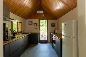 a kitchen with a white refrigerator and a wooden ceiling at Chalet du Lacus in Boutx +18 photos