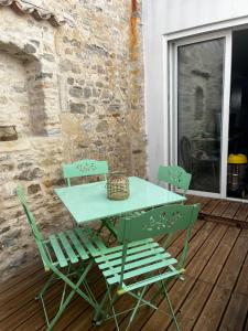 a green table and chairs on a patio at Séjour à Oléron Maison 3 étoiles in Saint-Denis-dʼOléron