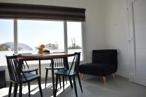 a dining room with a table and chairs and a window at Thronos in Vlychada +23 photos