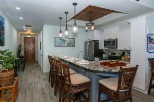 a kitchen with a island with chairs and a counter top at Mahalo Villa Beachfront Generator in Cruz Bay
