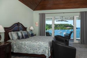 a bedroom with a bed and a view of the water at Mahalo Villa Beachfront Generator in Cruz Bay