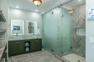 a bathroom with a glass shower and two sinks at Mahalo Villa Beachfront Generator in Cruz Bay