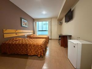 a hotel room with two beds and a flat screen tv at Hotel El Brujo Centro Histórico in Trujillo +38 photos