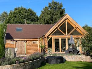 a wooden house with a porch and a patio at Holly Barn in Worcester