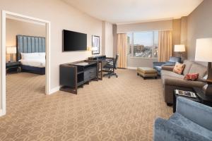a hotel room with a bed and a living room at The Marc Hotel in Milwaukee