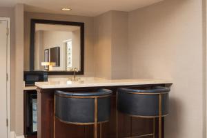 a bathroom with a counter with two blue bar stools at The Marc Hotel in Milwaukee +2 photos