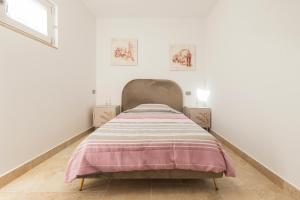 a bed in a white room with a pink blanket on it at B&B di MARE in Orta Nova +95 photos