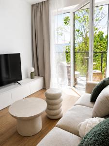 a living room with a couch and a table at Essentia Apartament 405 in Dziwnów