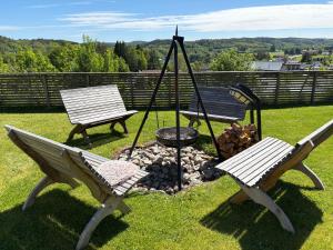 two park benches sitting next to a fire pit at Leilighet på RyenToppen med gapahuk in Kristiansand +22 photos