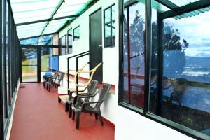 a room with chairs and windows with a view at Hotel Rancho Olimpo in Sesquilé
