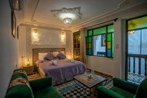 a bedroom with a bed with stained glass windows at Riad YAMNA - Quiet Desire in Fez