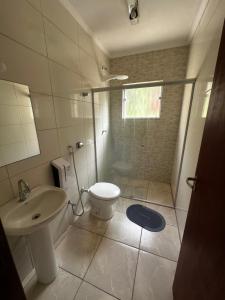 a bathroom with a toilet and a sink and a shower at Pousada Natalino Broleze in Águas de Lindoia
