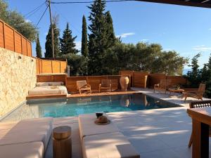 a swimming pool with a couch and chairs in a backyard at Horizon Collection in Agios Nikolaos
