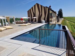 a swimming pool in front of a building with a resort at Montalbera Wine Suites in Montemagno
