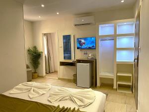 a bedroom with a bed and a desk and a television at Seven Pyramids View Inn - Rooftop Breakfast in Cairo