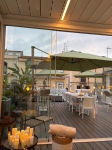 a patio with tables and chairs and an umbrella at Hotel Sorrento City in Sorrento