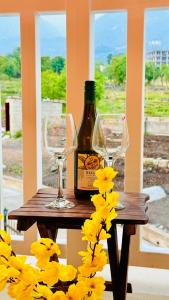 a bottle of wine and two glasses on a table at Frogs Aviator's Cottage in Dharmsāla