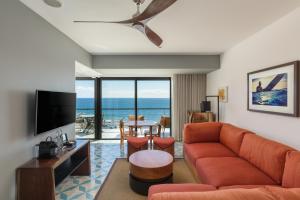 ein Wohnzimmer mit Sofa und Fernseher in der Unterkunft The Cape, A Thompson Hotel, by Hyatt in Cabo San Lucas