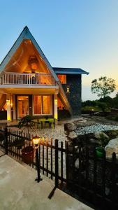 a house with a fence in front of it at Frogs Aviator's Cottage in Dharmsāla