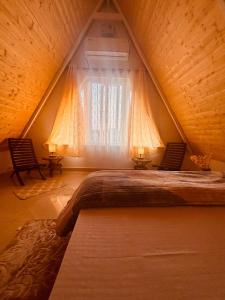 a large bed in a room with a window at Frogs Aviator's Cottage in Dharmsāla