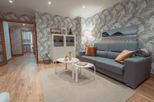 a living room with a blue couch and a bed at La Concha Pearl Beach Apartment in San Sebastián