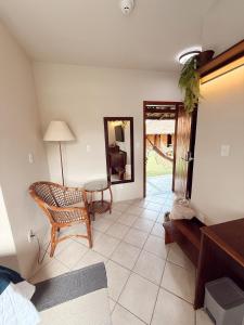 a living room with a chair and a mirror at Hotel Pousada da Lagoa - Casa Californiana in Garopaba