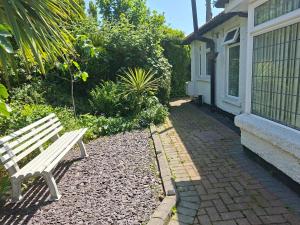 a white bench sitting outside of a house at Annasrose cottage in Middlesbrough