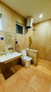 a bathroom with a sink and a toilet and a tub at Frogs Aviator's Cottage in Dharmsāla