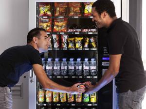 two men are standing in front of a soda machine at hotelF1 Pontarlier in Pontarlier +31 photos
