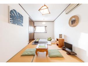 a living room with two beds and a tv at THINK - Vacation STAY 30630v in Ichigaya