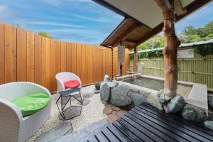 a backyard with a hot tub and chairs and a fence at THINK - Vacation STAY 30630v in Ichigaya