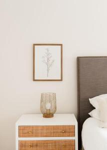 a bedroom with a dresser and a picture on the wall at Airy 3BD Cottage Yard Grill & Steps to Beach in Folly Beach