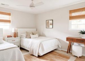 a white bedroom with two beds and a piano at Airy 3BD Cottage Yard Grill & Steps to Beach in Folly Beach