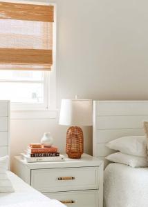 a bedroom with a nightstand with a lamp and a bed at Airy 3BD Cottage Yard Grill & Steps to Beach in Folly Beach
