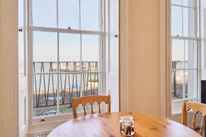 a dining room with a table and two windows at Coastal charm in Herne Bay