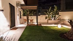 a courtyard with a green lawn in a house at Kayia City Garden, Luxury Suite with Private Garden in Heraklio
